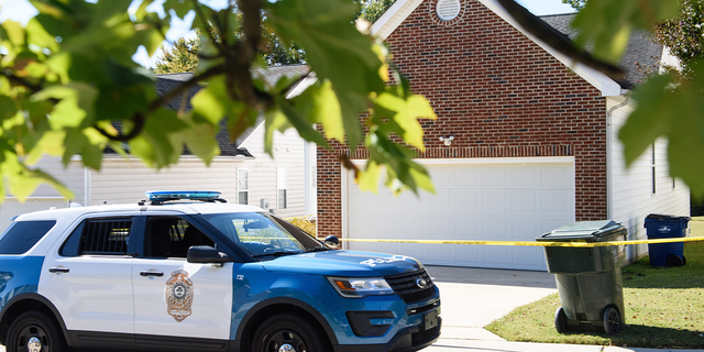 A police officer parks in front of the home of a suspect of a shooting that left five people dead and two others injured Oct. 14, 2022, in Raleigh, N.C.