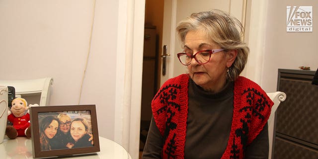 Milanka Ljubicic looks at a photo of her daughters, Ana and Aleksandra, in her apartment in Belgrade, Serbia on Monday, Jan. 9, 2023. Ljubicic's daughter, Ana Walshe, disappeared from her Cohasset, Massachusetts home on New Year's Day.