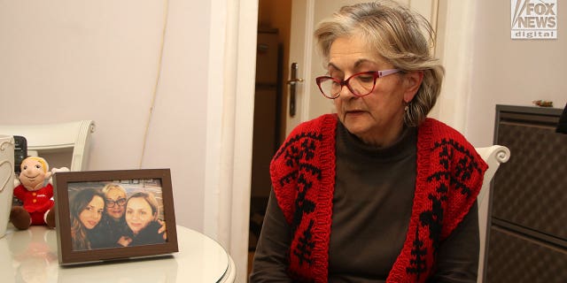 Milanka Ljubicic looks at a photo of her daughters, Ana and Aleksandra, in her apartment in Belgrade, Serbia on Monday, Jan. 9, 2023. Ljubicic's daughter, Ana Walshe, disappeared from her Cohasset, Massachusetts home on New Year's Day.