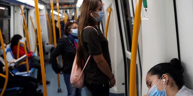 A masked passenger sleeps on the subway on the first day of mask use on public transport in Madrid, Spain, May 4, 2020. 