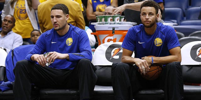 Stephen Curry, right, and Klay Thompson of the Golden State Warriors sit on the bench before a game against the New Orleans Pelicans at the Smoothie King Center on December 4, 2017 in New Orleans.