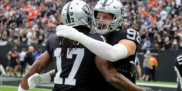 #17 Davante Adams y #98 Maxx Crosby de Las Vegas Raiders se encuentran antes del partido contra los Denver Broncos en el Allegiant Stadium el 2 de octubre de 2022 en Las Vegas, Nevada.