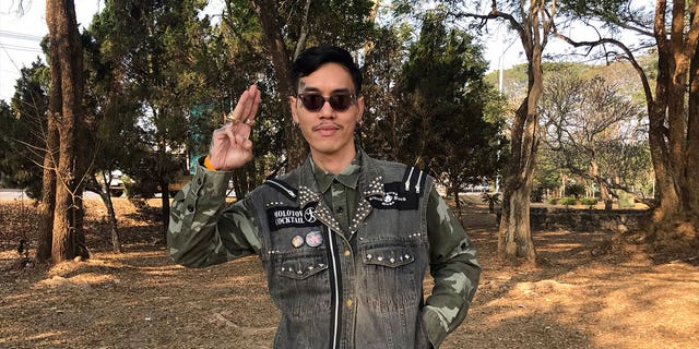 Political activist Mongkhon Thirakot flashes the pro-democracy gesture of a three-finger salute ahead of going to court in Thailand, on Jan. 26, 2023. 