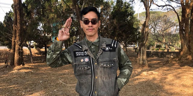 Political activist Mongkhon Thirakot flashes the pro-democracy gesture of a three-finger salute ahead of going to court in Thailand, on Jan. 26, 2023. 