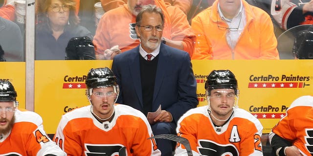 Philadelphia Flyers head coach John Tortorella, standing, watches the game against the New Jersey Devils at Wells Fargo Center on Oct. 13, 2022, in Philadelphia.