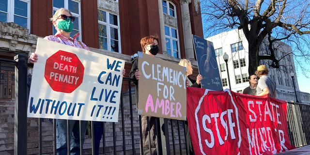 Sue Gibson, left, of Jefferson City, and Jay Castilow, of Columbia, hold signs along with others outside the Missouri Supreme Court building while protesting the execution of Amber McLaughlin on Tuesday, Jan. 3, 2023, in Jefferson City, Missouri. McLaughlin was convicted of killing Beverly Guenther in 2003.