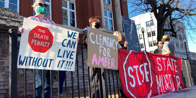 Sue Gibson, left, of Jefferson City, and Jay Castilow, of Columbia, hold signs along with others outside the Missouri Supreme Court building while protesting the execution of Amber McLaughlin on Tuesday, Jan. 3, 2023, in Jefferson City, Missouri. McLaughlin was convicted of killing Beverly Guenther in 2003.