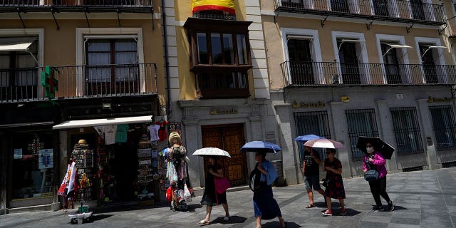 Tourists shelter under umbrellas during a heatwave in Toledo, Spain, on June 28, 2019. 