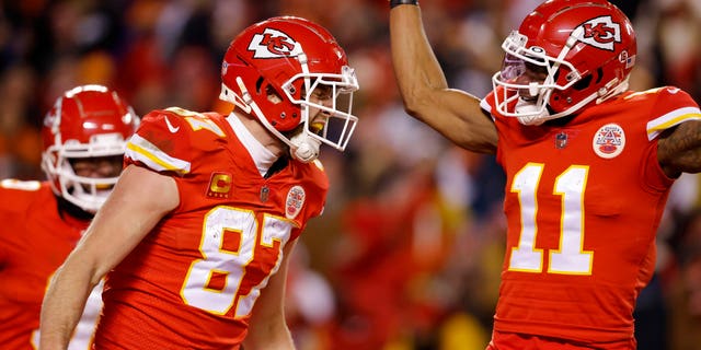 Travis Kelce #87 of the Kansas City Chiefs celebrates with teammate Marquez Valdes-Scantling #11 after scoring a touchdown against the Cincinnati Bengals during the second quarter in the AFC Championship Game at GEHA Field at Arrowhead Stadium on January 29 2023 in Kansas City, Missouri.