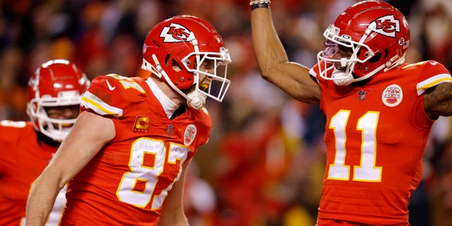 Travis Kelce #87 of the Kansas City Chiefs celebrates with teammate Marquez Valdes-Scantling #11 after scoring a touchdown against the Cincinnati Bengals during the second quarter in the AFC Championship Game at GEHA Field at Arrowhead Stadium on January 29 2023 in Kansas City, Missouri.