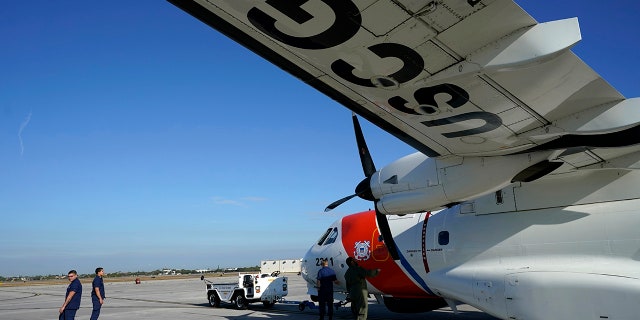 United States Coast Guard officials prepare an aircraft for a patrol to search for migrants over the Florida Straits, Friday, Jan. 20, 2023, in Opalocka, Fla.