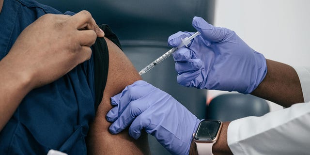 La jefa de medicina de emergencia de Lenox Hill, Eve Durosso, recibe una vacuna contra el COVID-19 de la Dra. Michelle Chester en el Centro Médico Judío de Long Island.