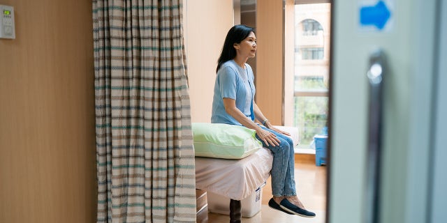 woman sitting on hospital bed