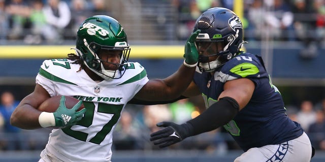 Zonovan Knight #27 of the New York Jets carries the ball against the Seattle Seahawks during the second half of the game at Lumen Field on January 1, 2023 in Seattle, Washington.