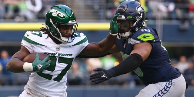 Zonovan Knight #27 of the New York Jets carries the ball against the Seattle Seahawks during the second half of the game at Lumen Field on January 1, 2023 in Seattle, Washington.