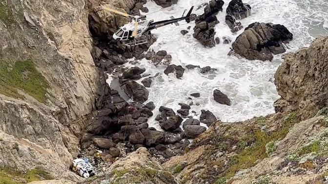 A white Tesla is seen off the 'Devil's Slide' cliff in California after the driver intentionally drove off the cliff, authorities said