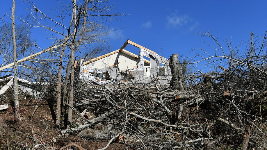 Knocked down trees and a home