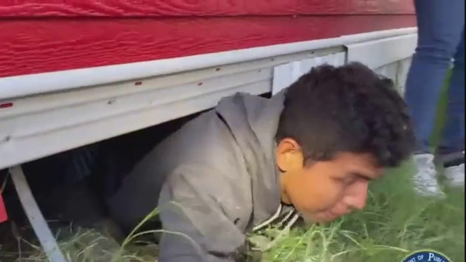 migrant crawling out from under house