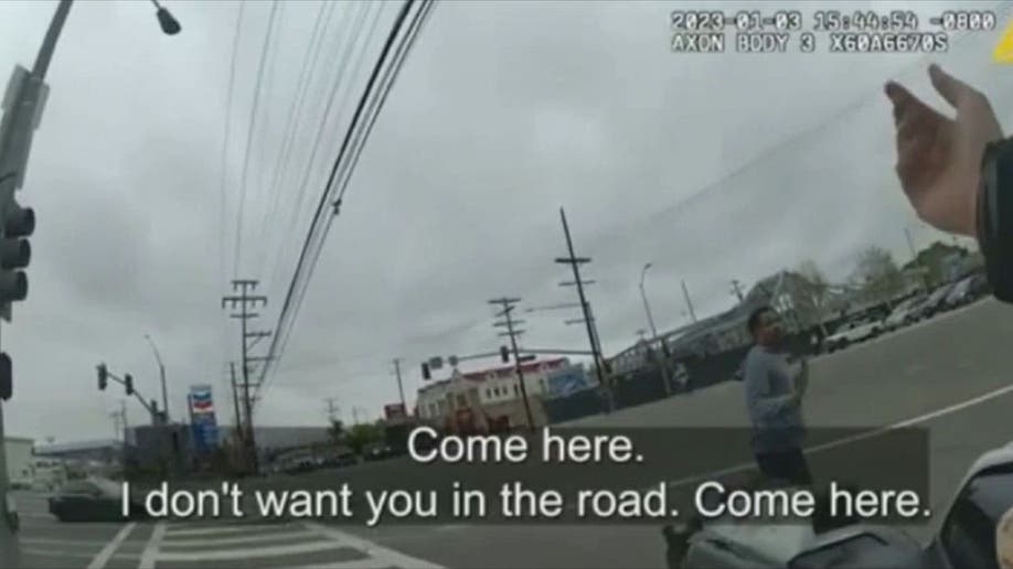 A police officer asks Keenan Anderson to get out of the road during his arrest