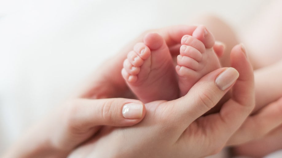 baby feet in mother's hands