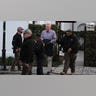 A man is escorted out of a courthouse by police.