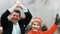 Ronald and Nancy Reagan waving and clasping hands in victory at Reagan's first inauguration, January 20, 1981.
