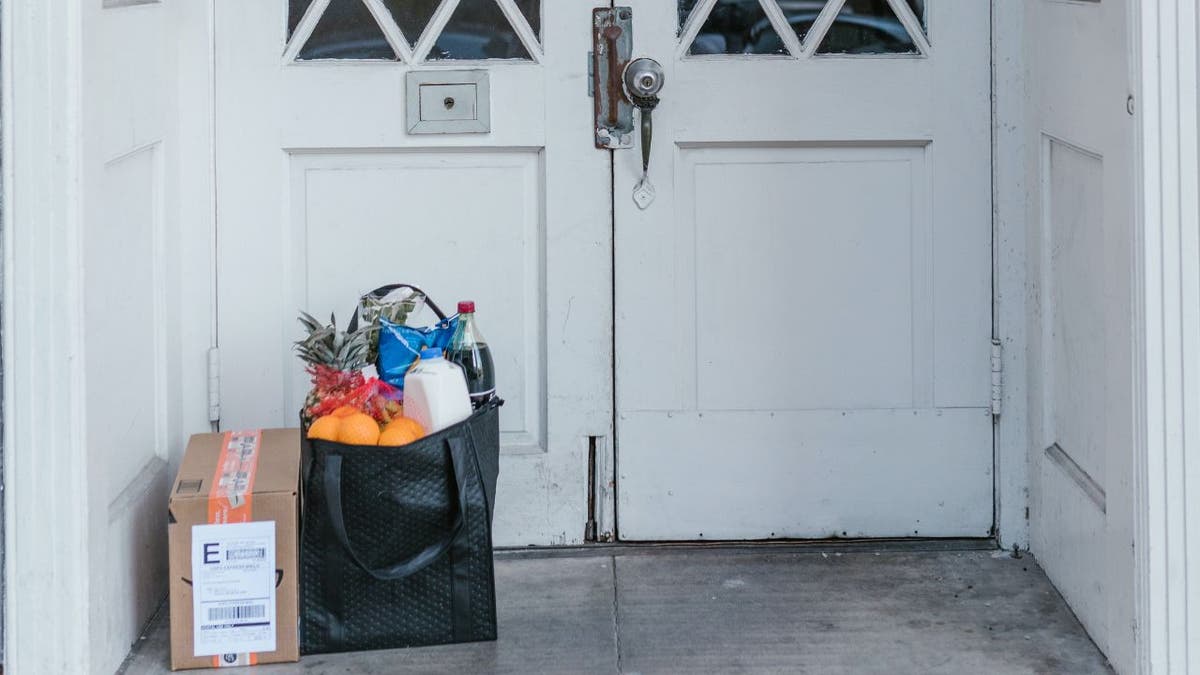 Front doors at a house with groceries in front