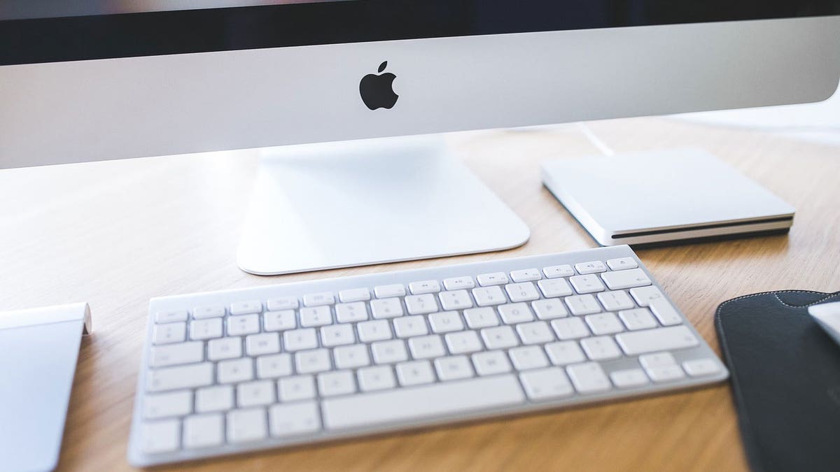 Photo of an Apple computer monitor and keyboard.