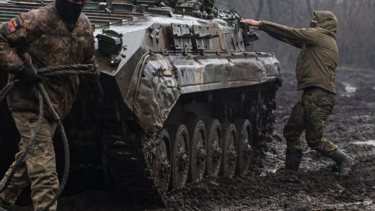 Ukrainian service members are seen next an infantry fighting vehicle near the frontline town of Bakhmut, amid Russia's attack on Ukraine, in Donetsk region, Ukraine Feb. 25, 2023. 