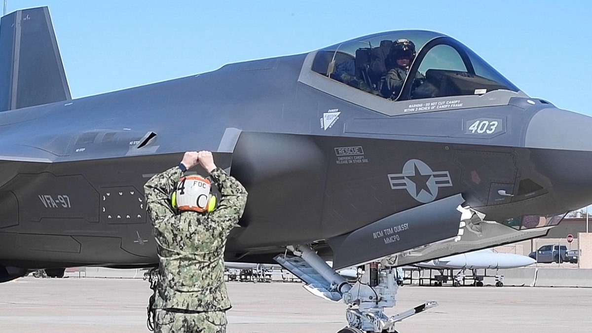 A photo of someone gesturing to a plane