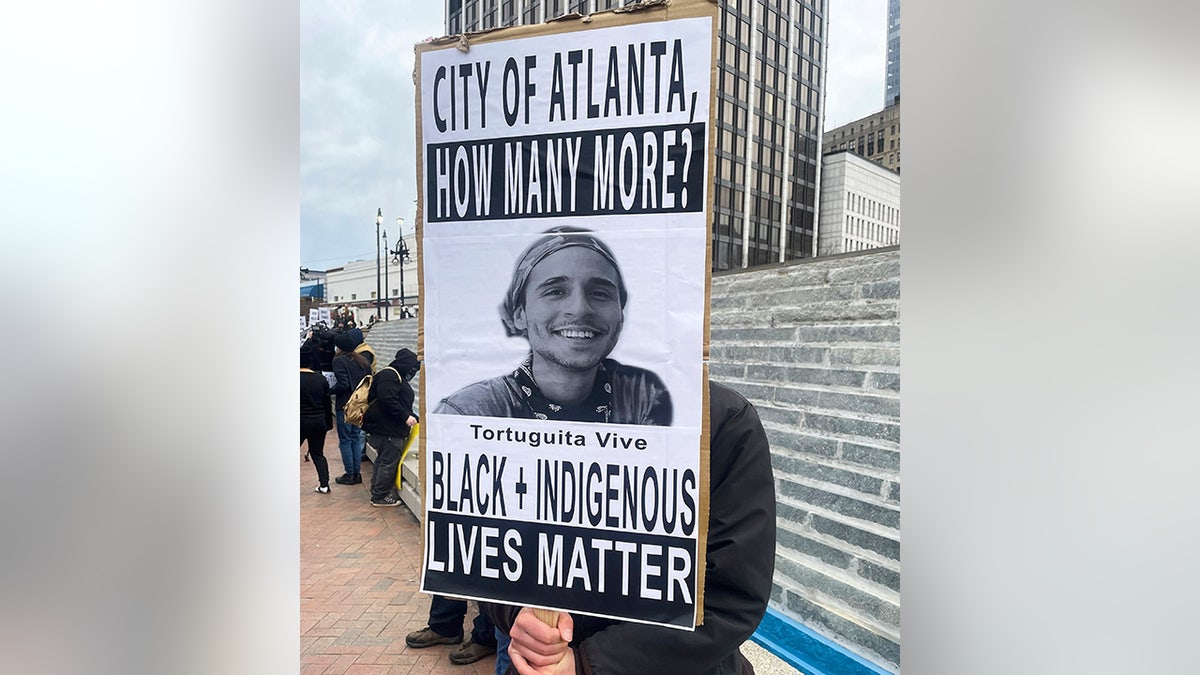 Cop City protester holds photo of Tortuguita