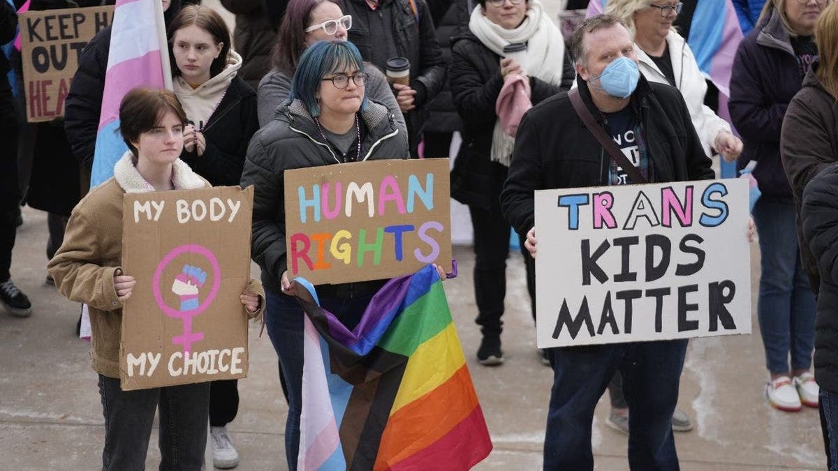 transgender activists holding protest signs