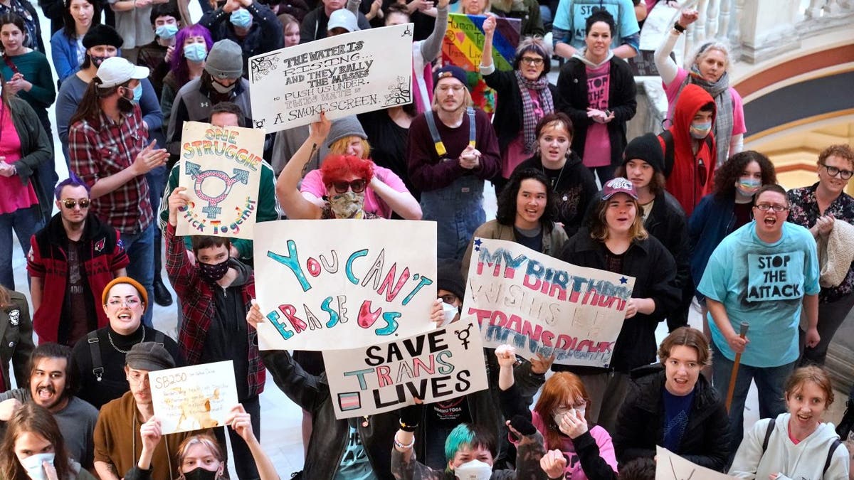 Trans-rights activists protest outside the House chamber at the state Capitol