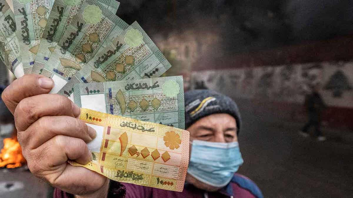  A protester holds Lebanese pounds