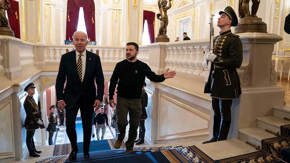 President Joe Biden and Ukrainian President Volodymyr Zelenskyy walk up stairs inside Mariinsky Palace.