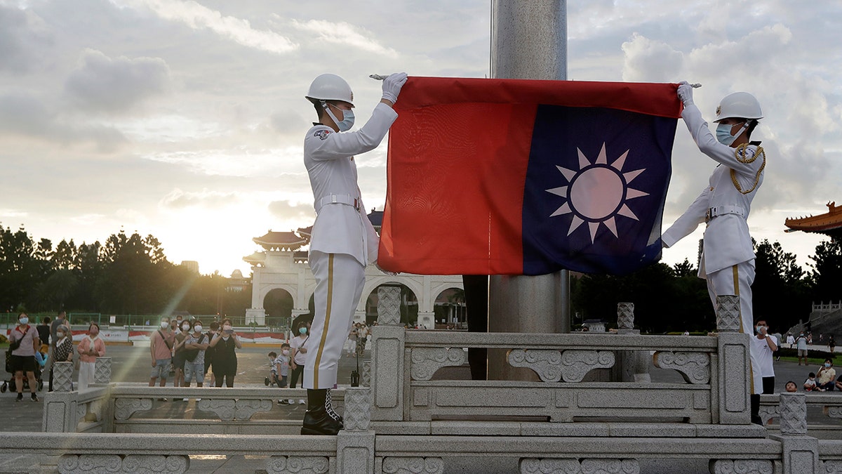 Two officials holding a flag