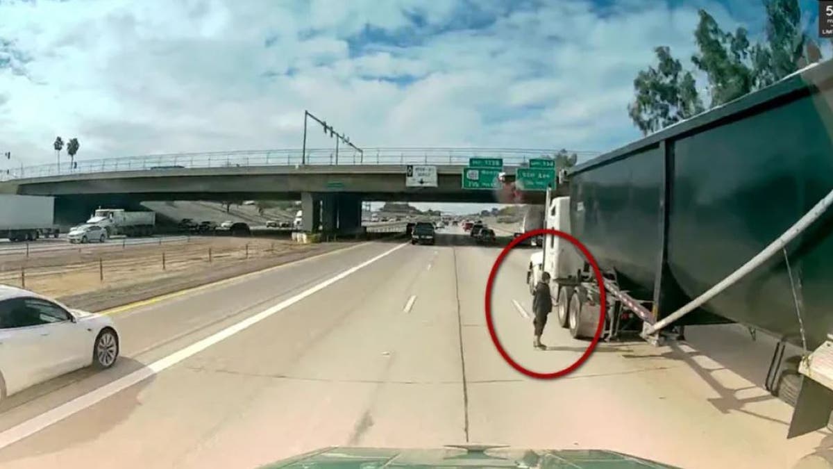 Arizona interstate crosser as semi-truck speeds by