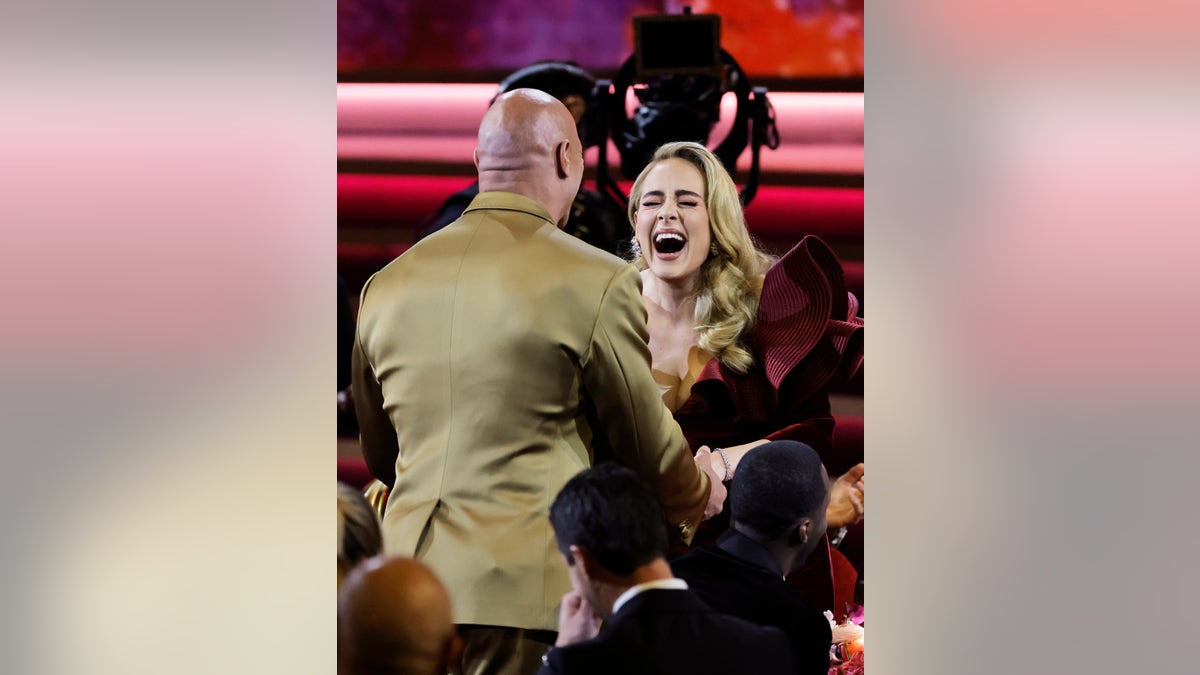 Adele and Dwayne Johnson hug at Grammys