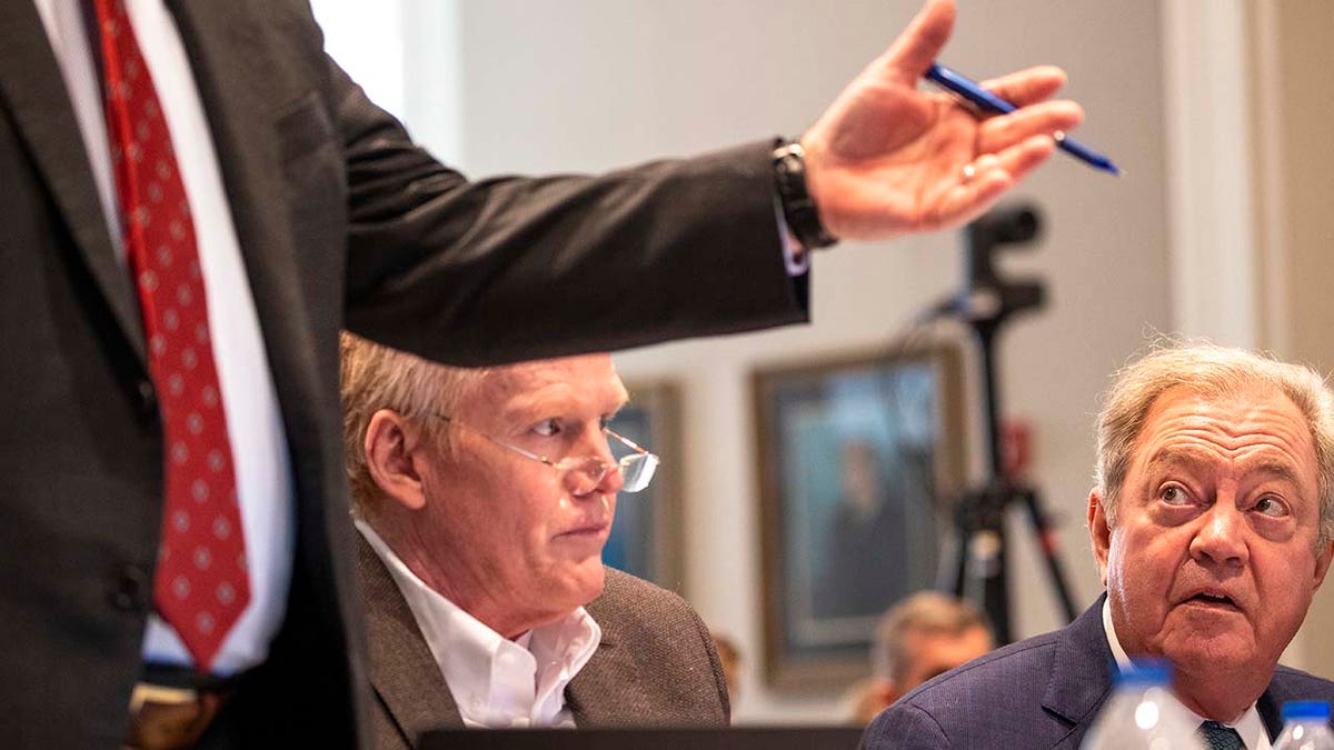 A man looks on while inside a courtroom.