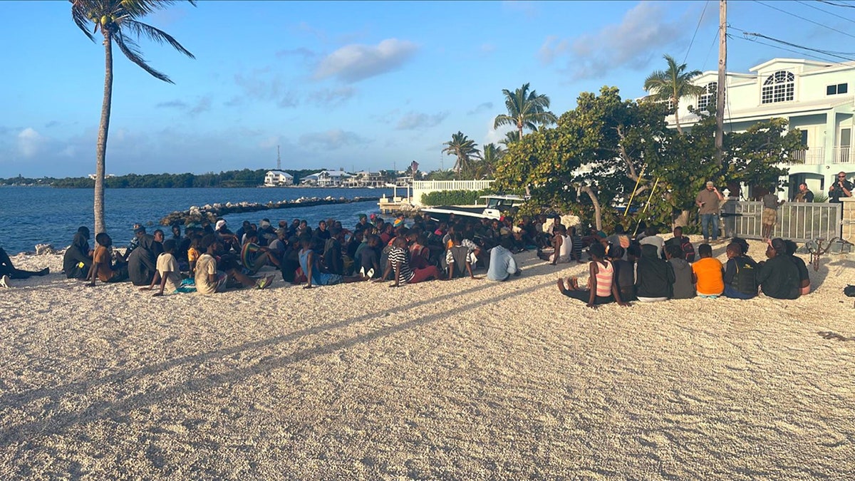 Haitian migrants sitting on beach
