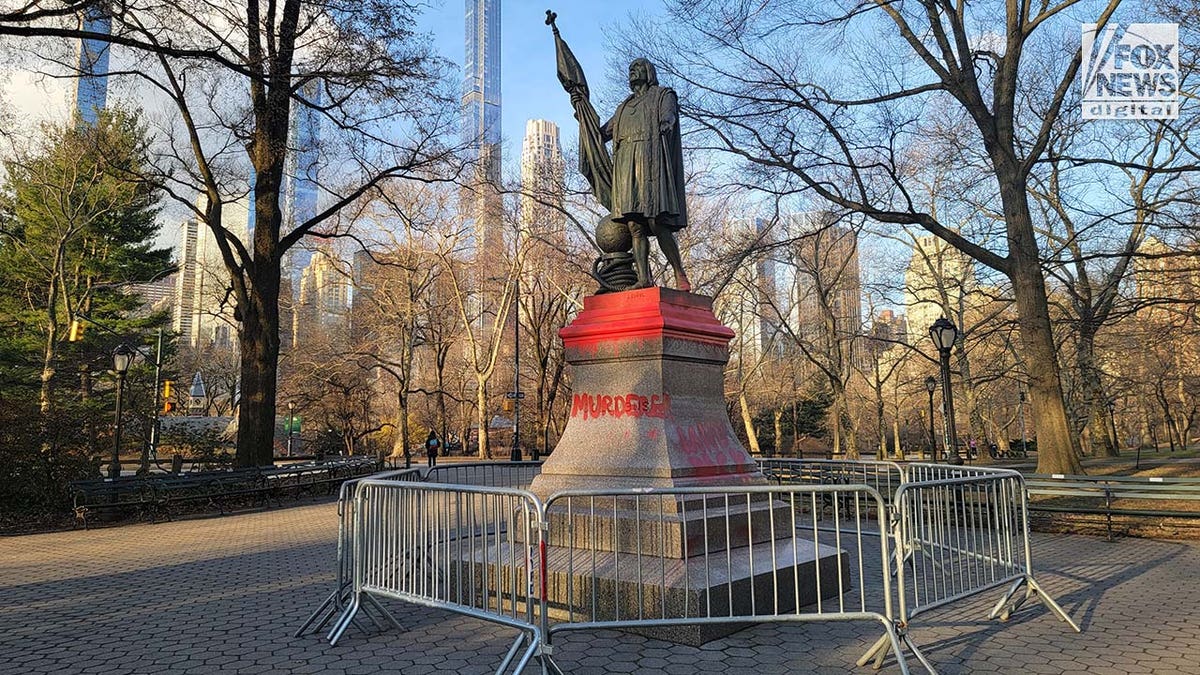 A statue of Christopher Columbus is vandalized with red paint.