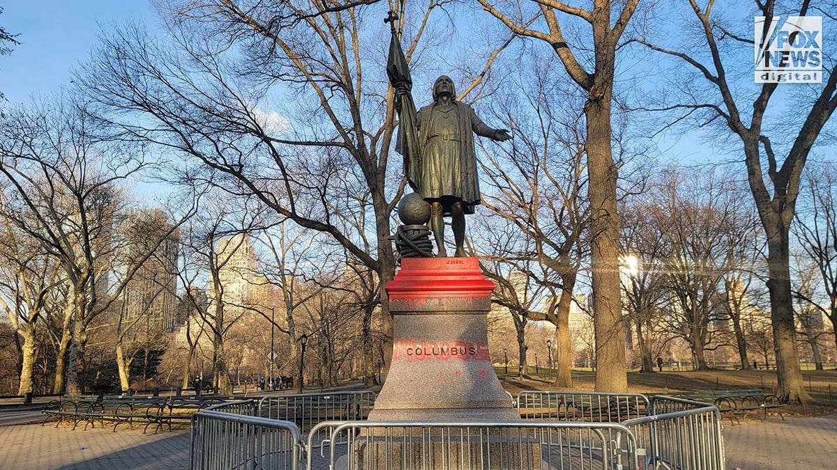 A statue of Christopher Columbus is vandalized with red paint.
