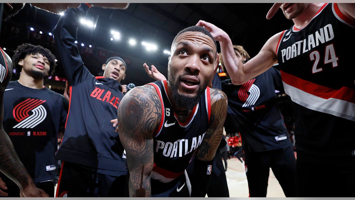 Damian Lillard surrounded by teammates