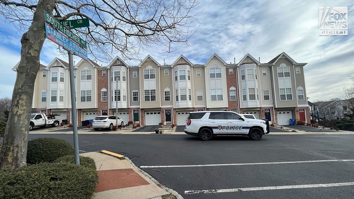 Police cars stationed outside of a New Jersey apartment complex during daytime