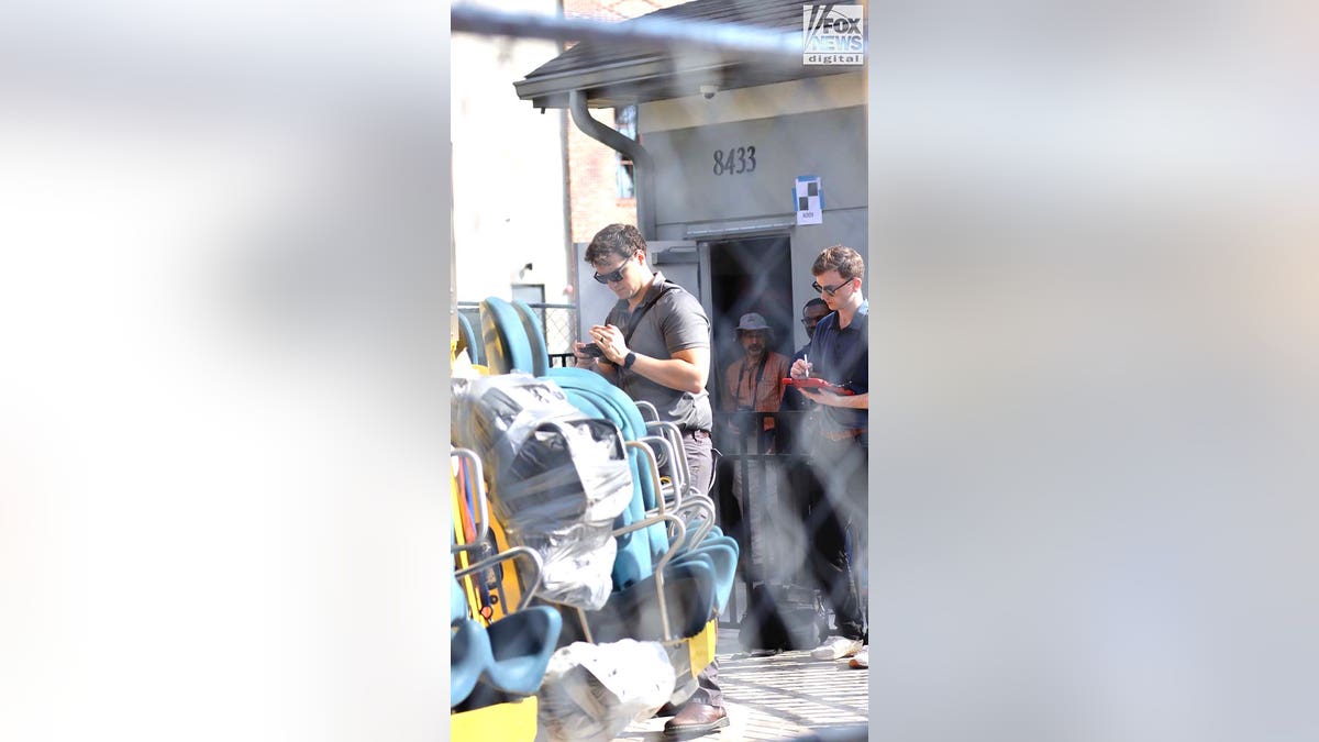 A man conducts an inspection of a theme park ride.