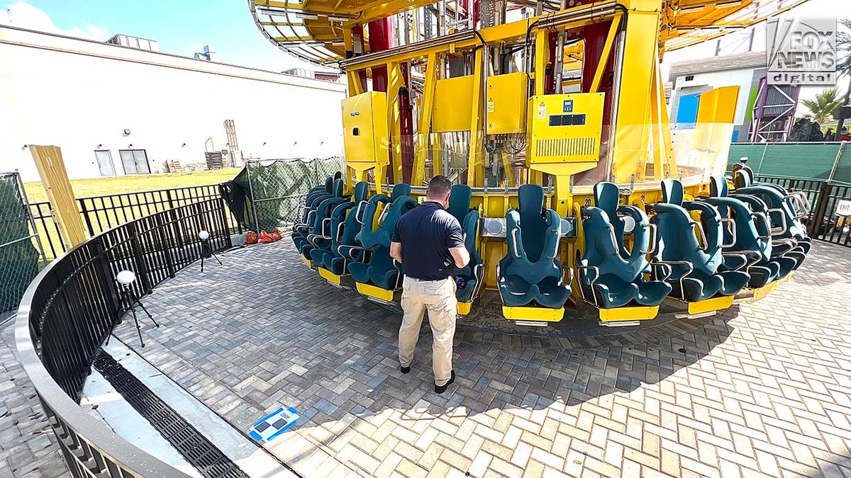 A man conducts an inspection of a theme park ride.