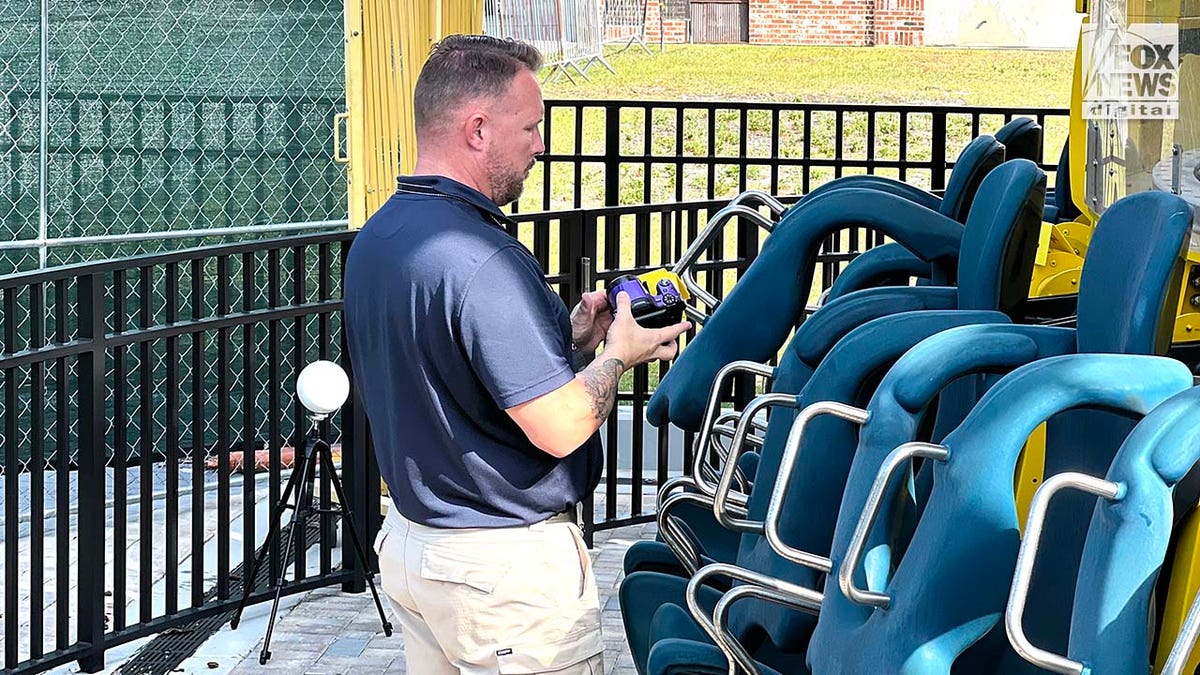 A man conducts an inspection of a theme park ride.
