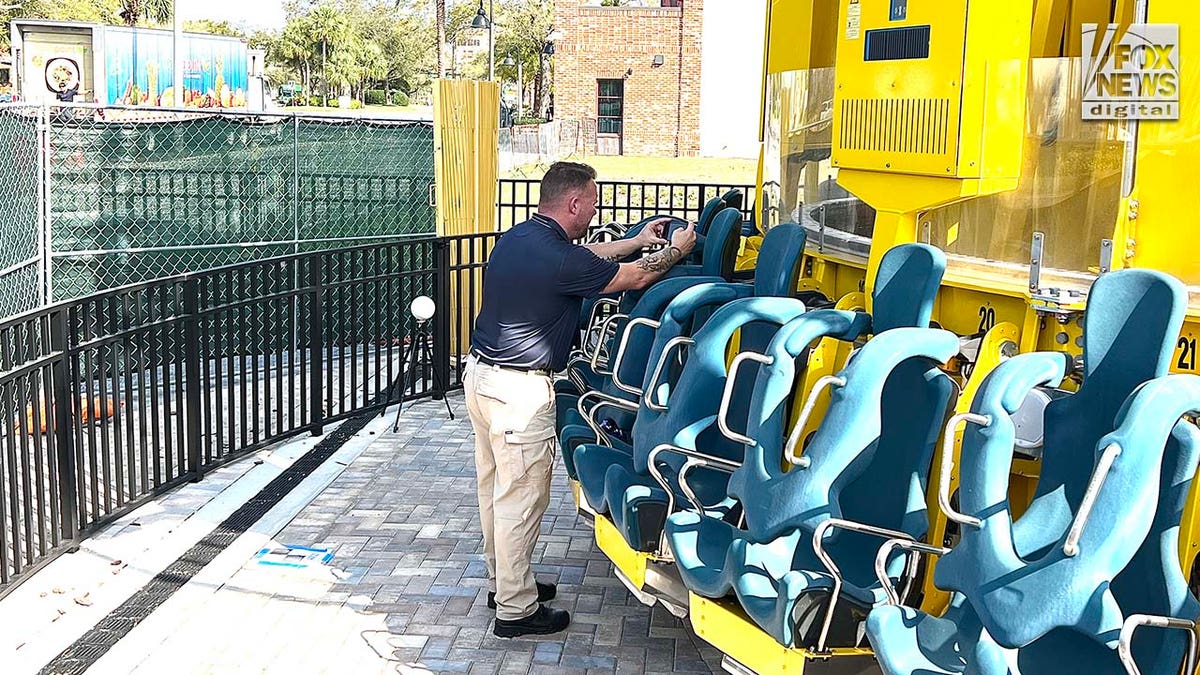 A man conducts an inspection of a theme park ride.