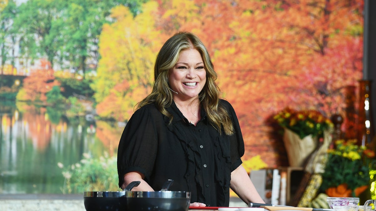 Valerie Bertinelli stands behind a cooktop counter during a Food Network event