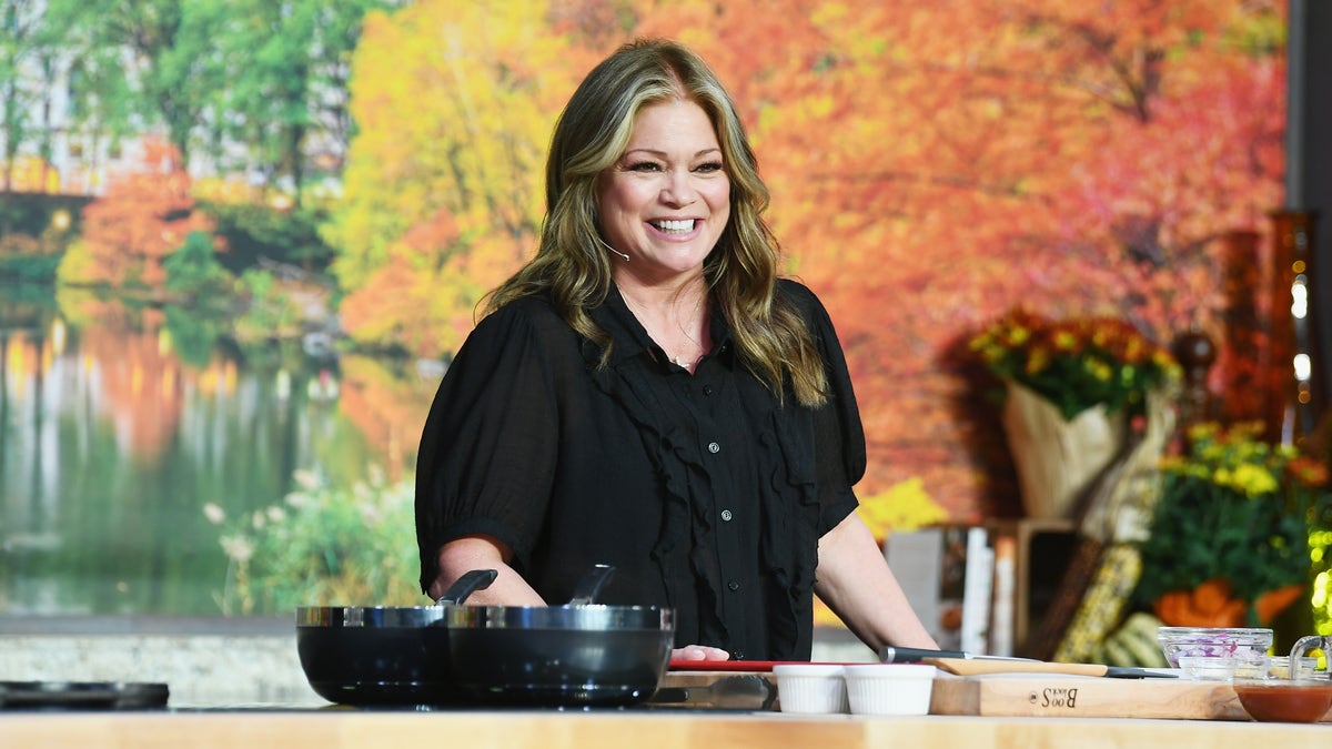 Valerie Bertinelli stands behind a cooktop counter during a Food Network event